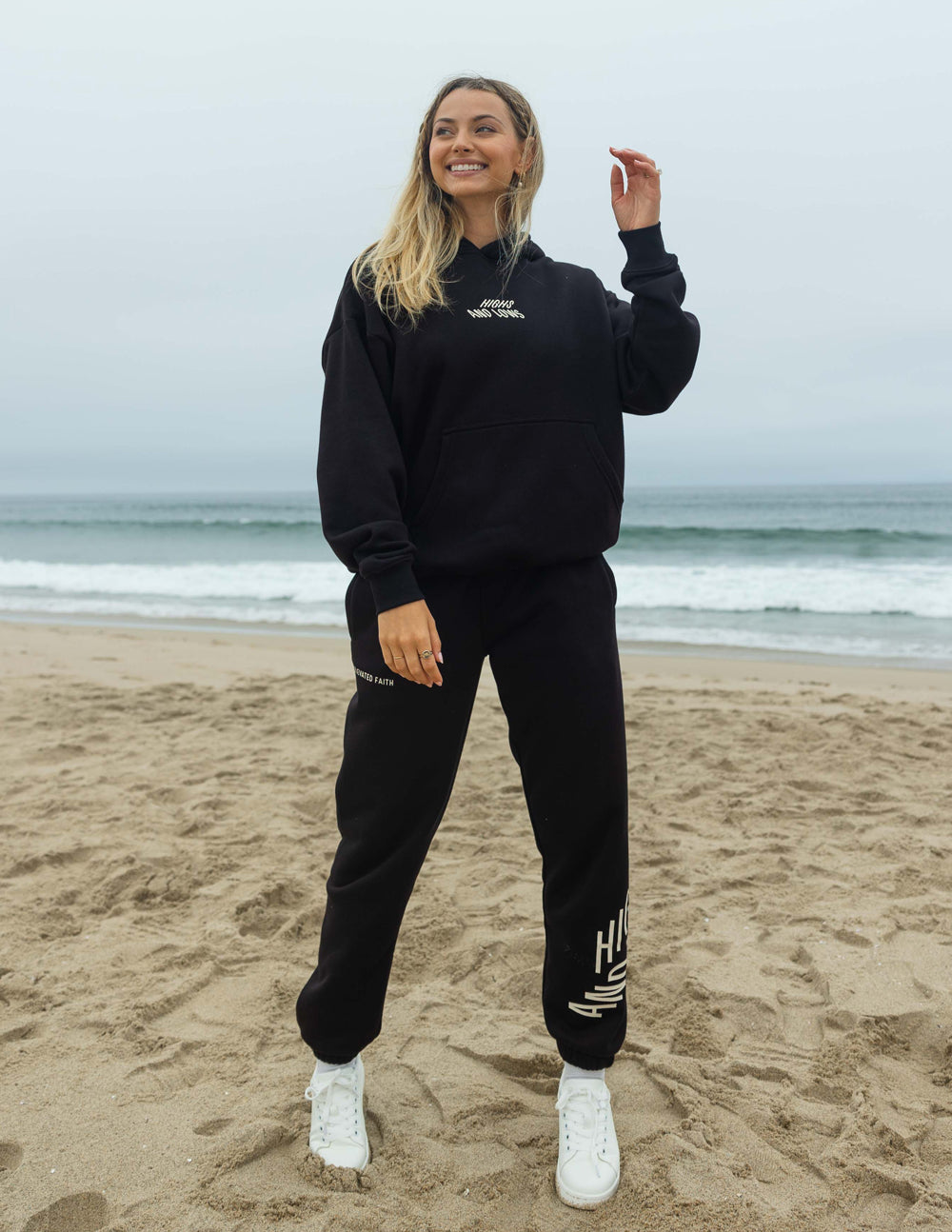 Black unisex pullover hoodie with small chest logo, hood, and front pocket