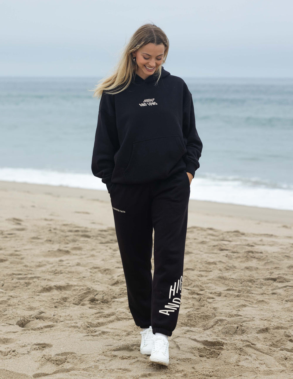 Unisex black sweatpants with white logo patch on right leg and elastic waistband