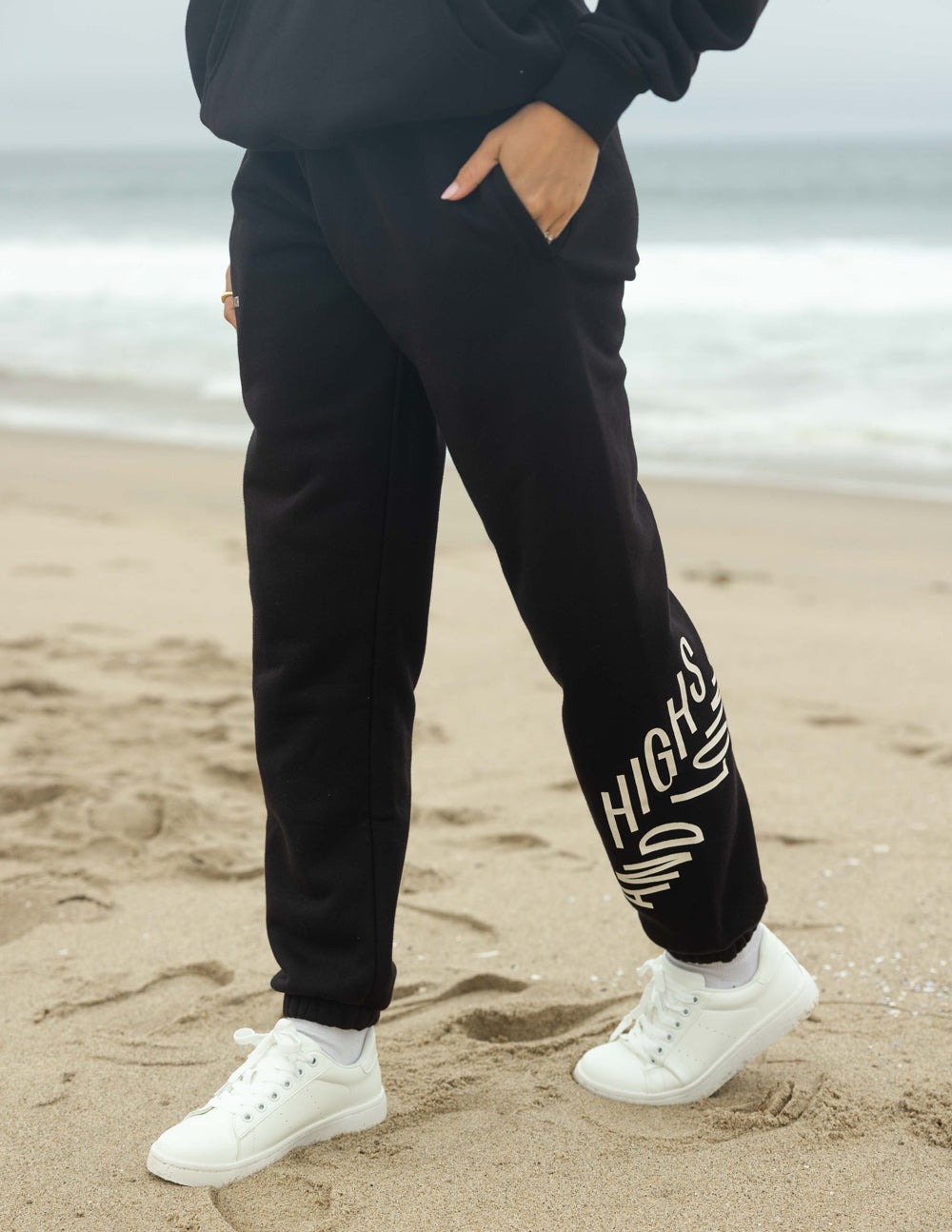 Unisex black sweatpants with ribbed cuffs and white Highs and Lows logo