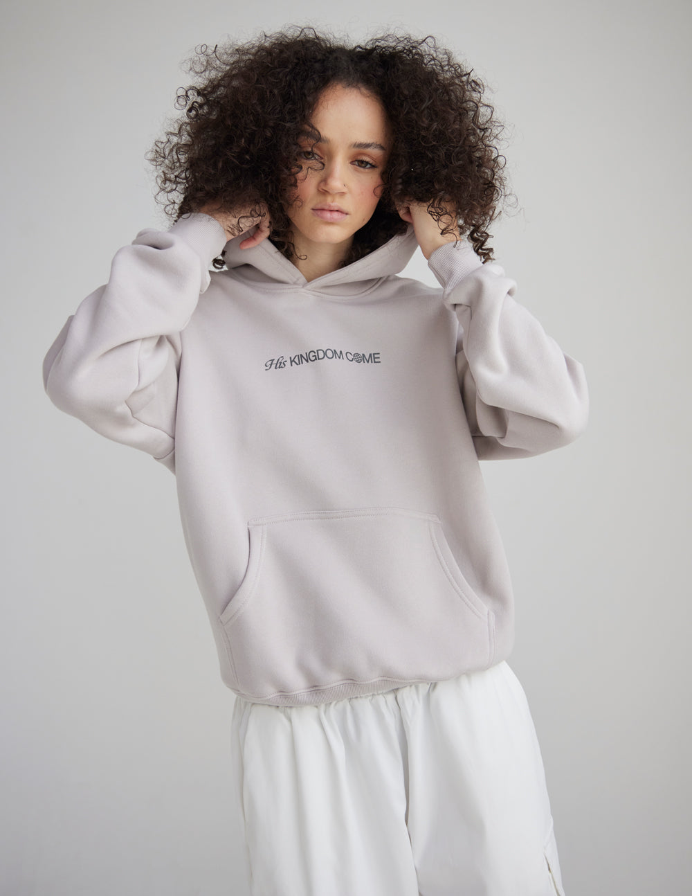 Light gray unisex hoodie with front logo and ribbed cuffs; hood down