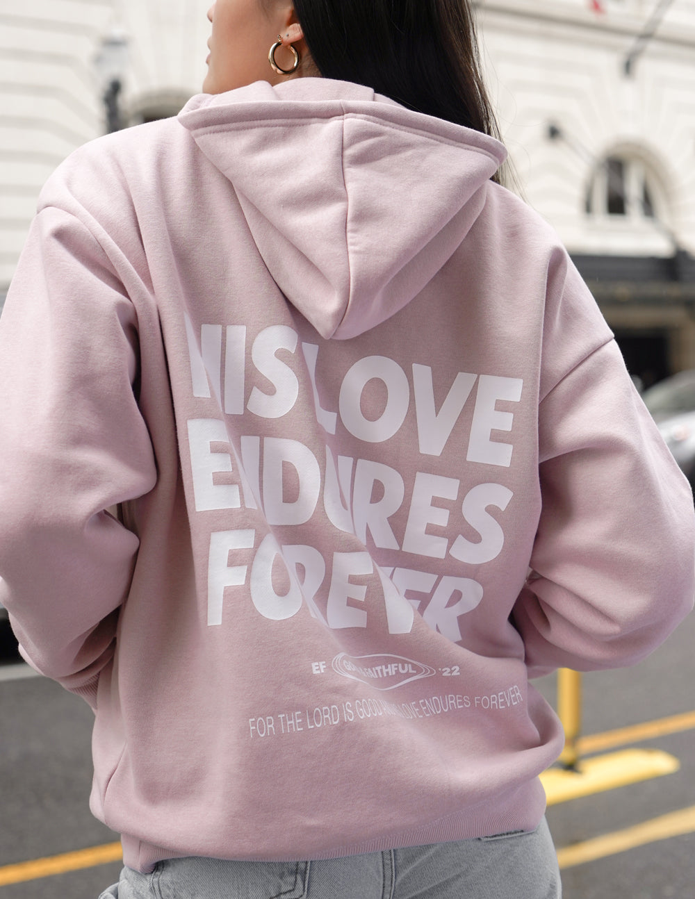 Unisex pink hoodie back view with large “HIS LOVE ENDURES FOREVER” lettering