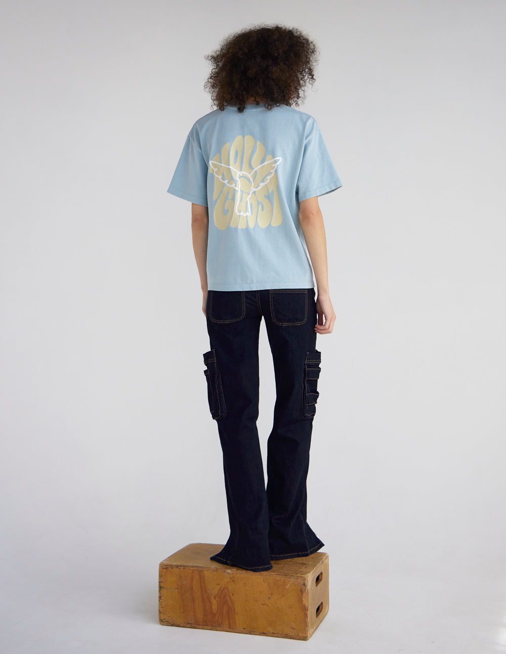 Light blue heavyweight T-shirt shown from back with large graphic print, short sleeves.