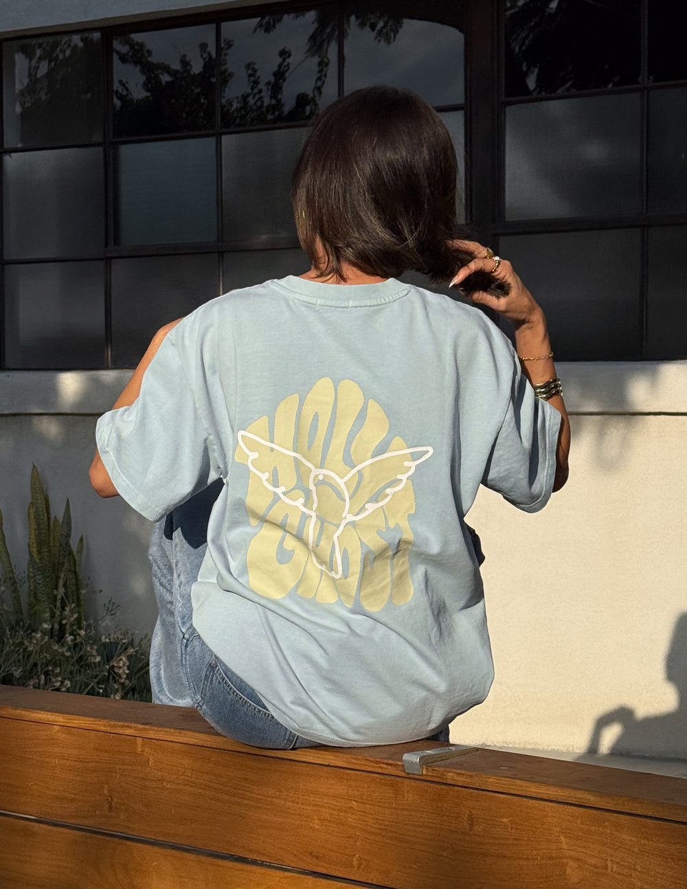 Light blue T-shirt close-up with large back graphic print and crew neck.