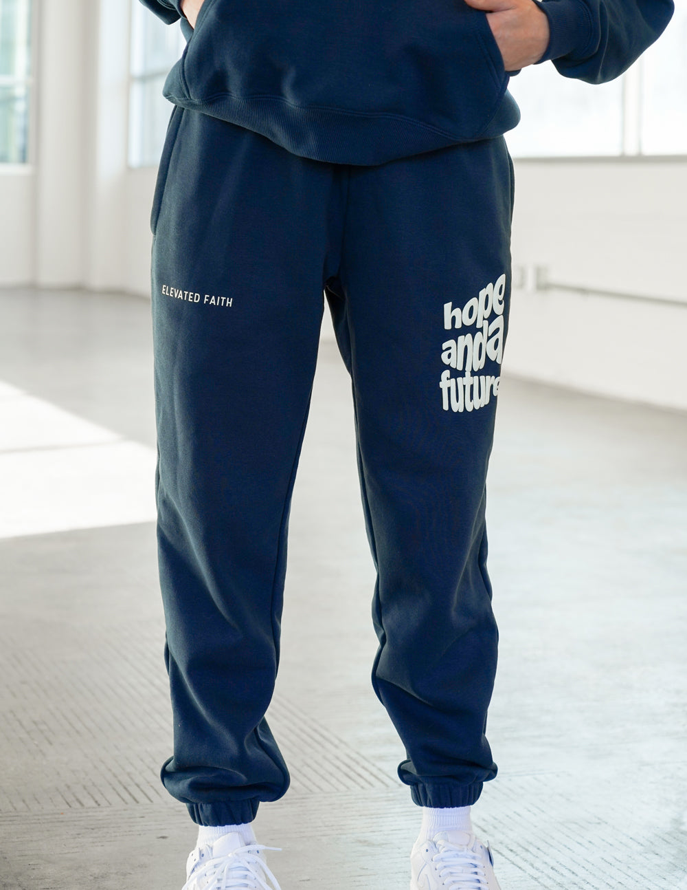 Unisex navy sweatpants with “Hope and a Future” text logo at the knee