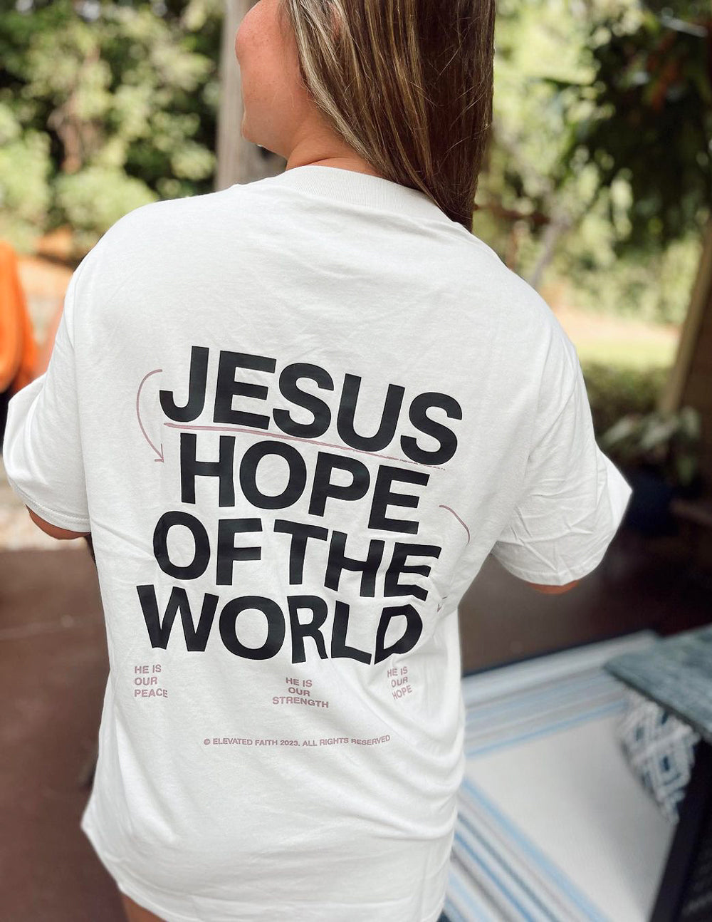 Unisex graphic tee, white, close back view with text "JESUS HOPE OF THE WORLD"