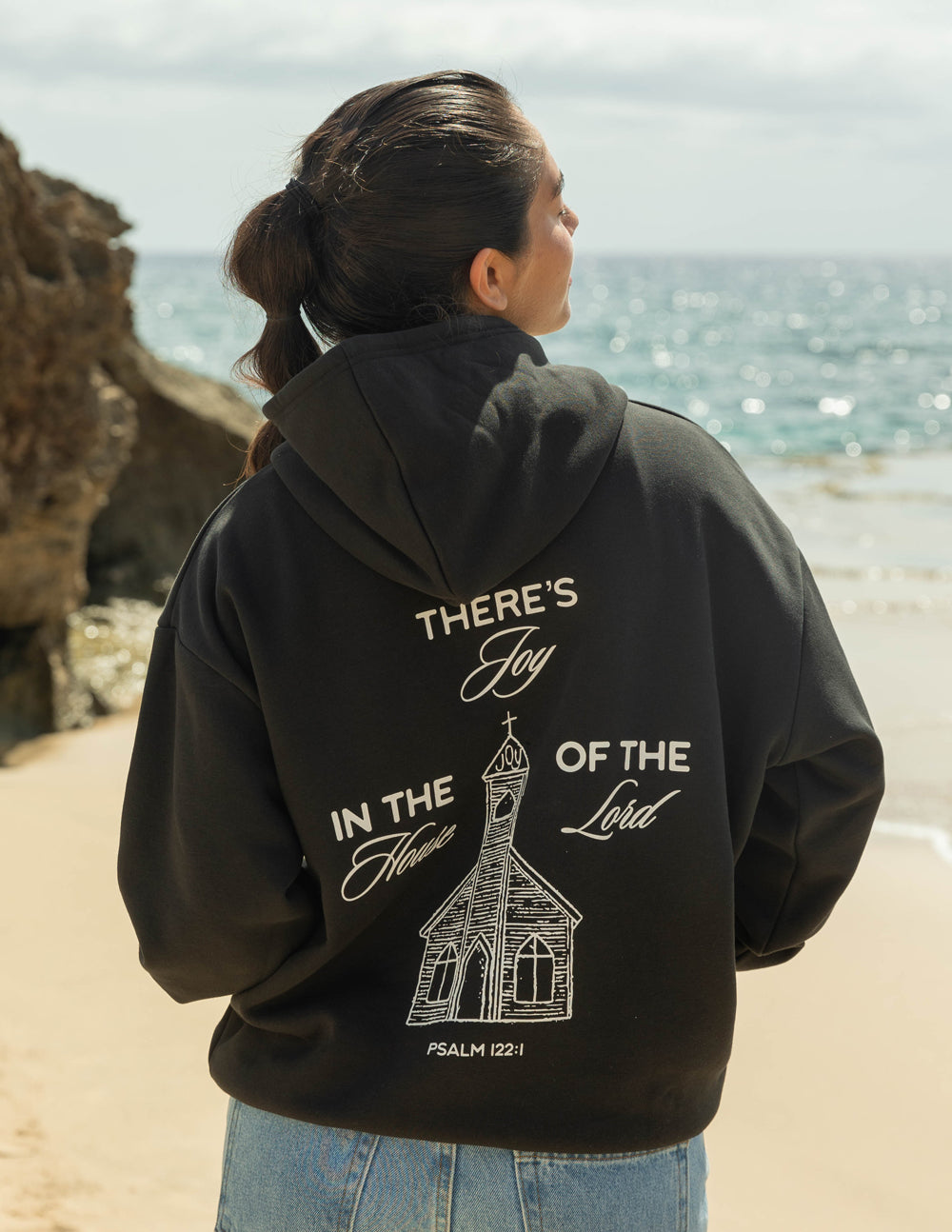 Black unisex hoodie with back print featuring house illustration and text