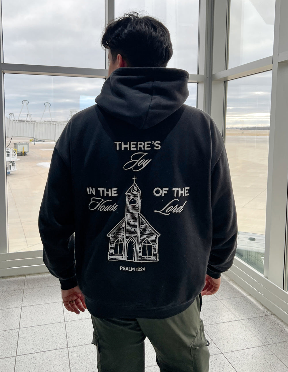 Black unisex hoodie with back print of church illustration and text