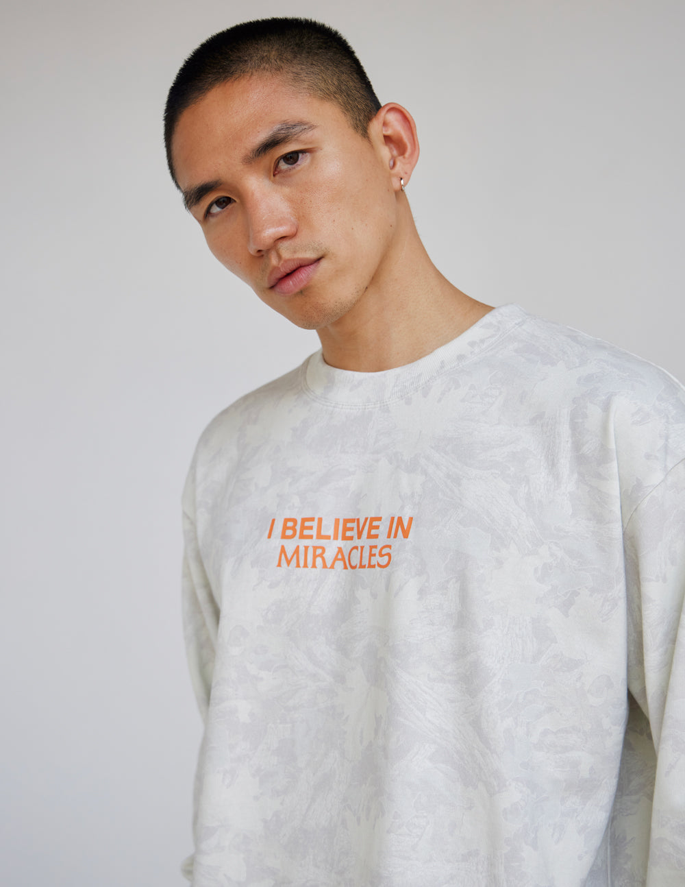 Long-sleeve heavyweight tee in white with orange front logo text