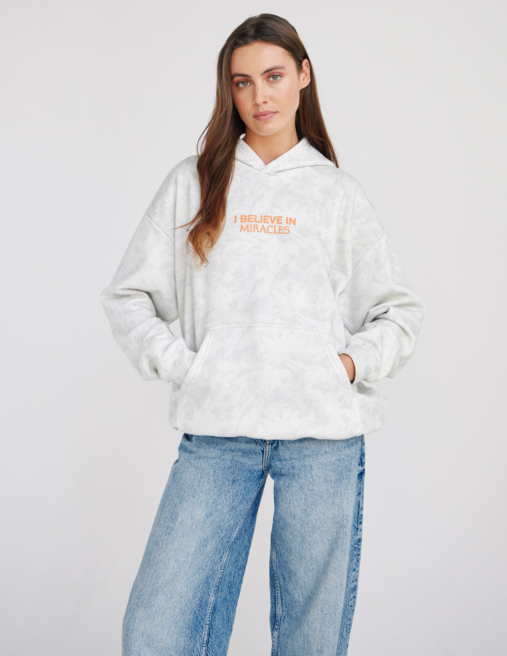 Light camo unisex hoodie with hood and orange "I Believe in Miracles" chest print