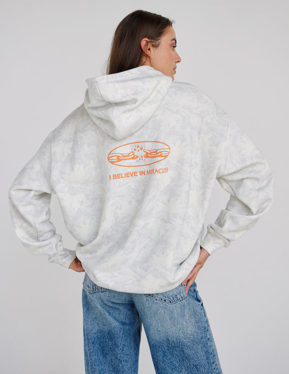 Light camo unisex hoodie with large orange back graphic "I Believe in Miracles"