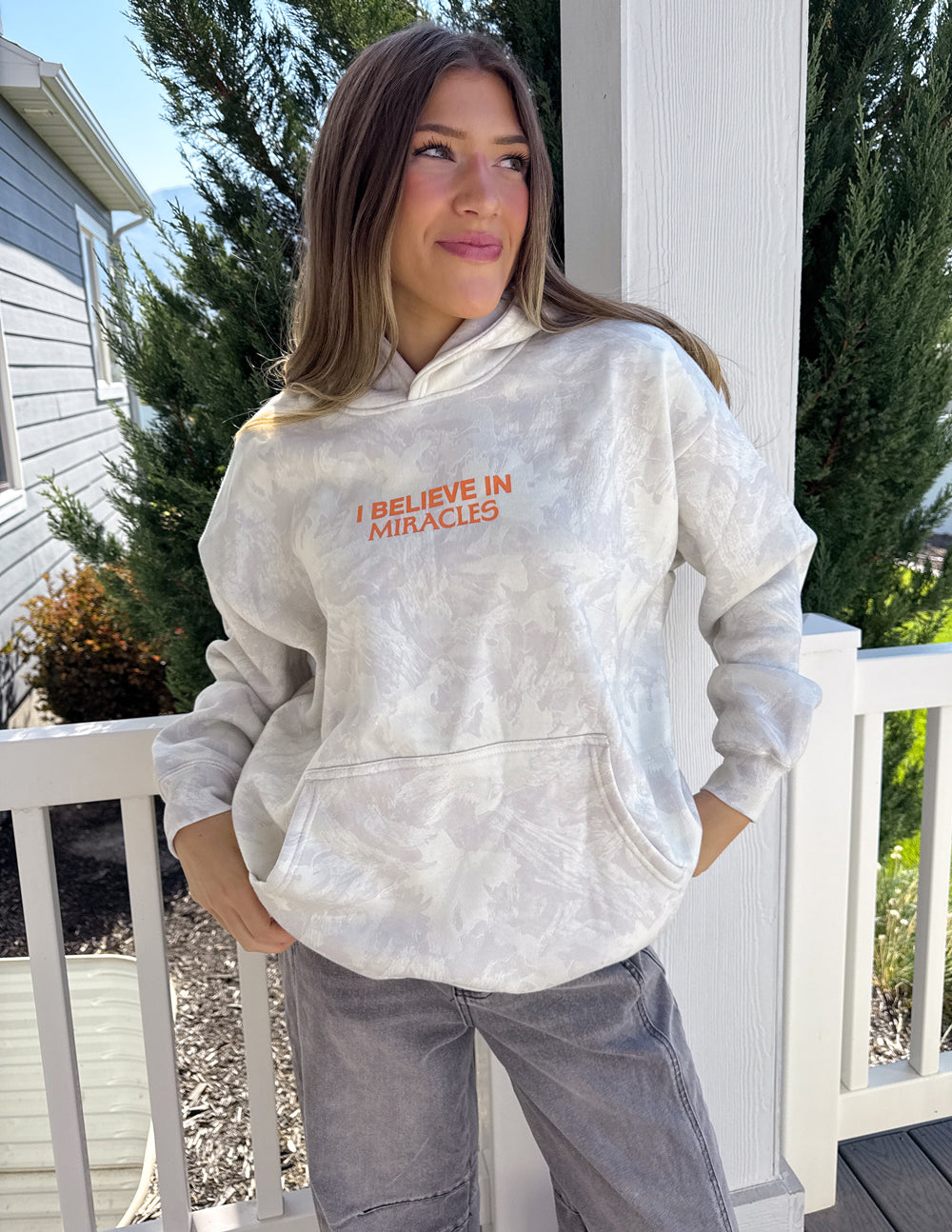 Light camo unisex hoodie with hood and orange "I Believe in Miracles" front print