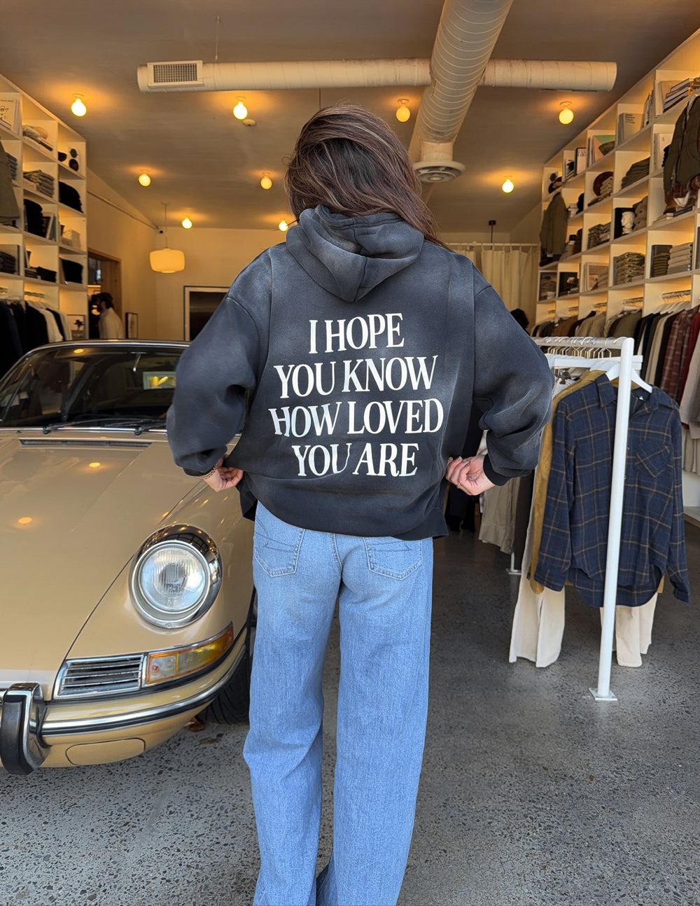 Dark unisex hoodie with back graphic print, hood, and kangaroo pocket