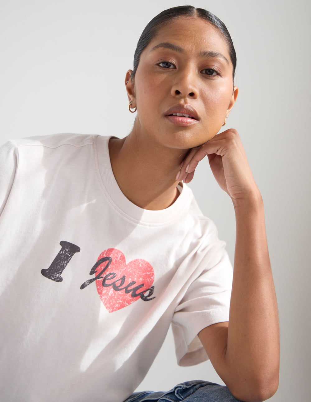 Cropped white women's tee close-up with red heart 'Jesus' script and black I