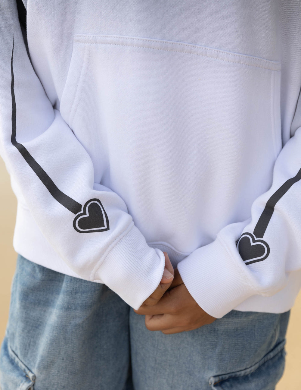 Unisex gray hoodie sleeve cuff with heart graphic and black drawstring ends