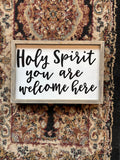Wood-framed Christian welcome sign reading 'Holy Spirit you are welcome here'