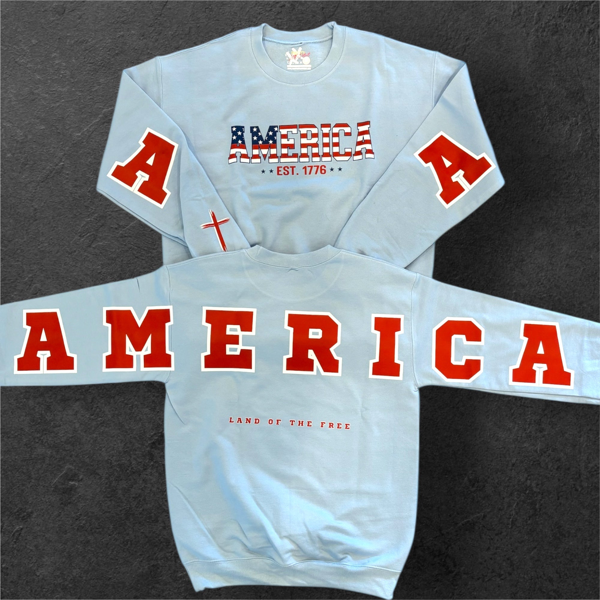 Light blue crewneck sweatshirt with large red 'AMERICA' lettering and flag-style emblem