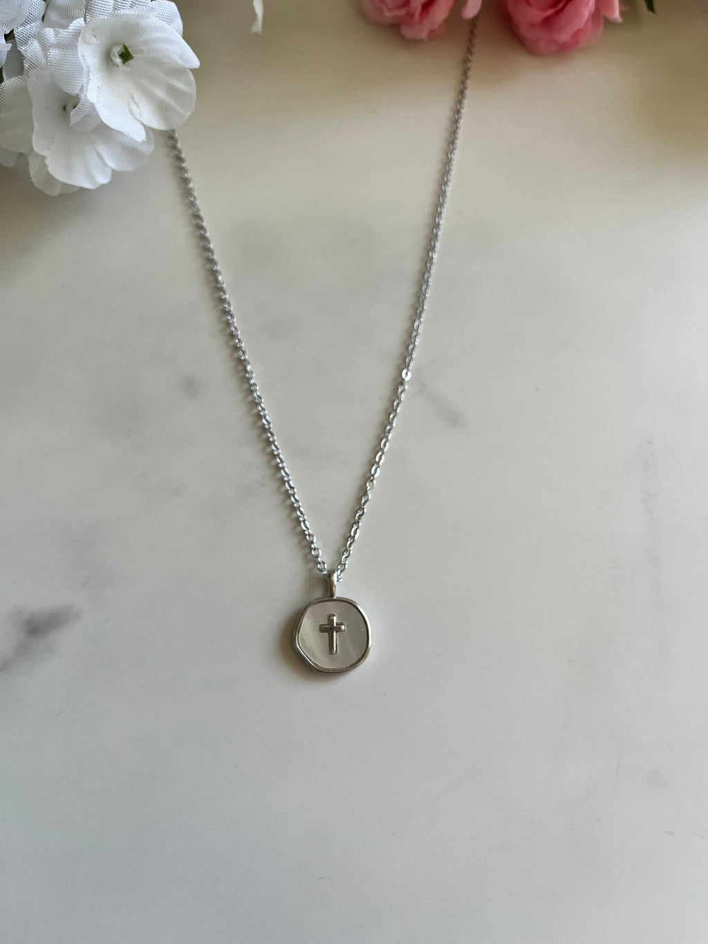 Silver cross pendant necklace with round disc charm centered on chain