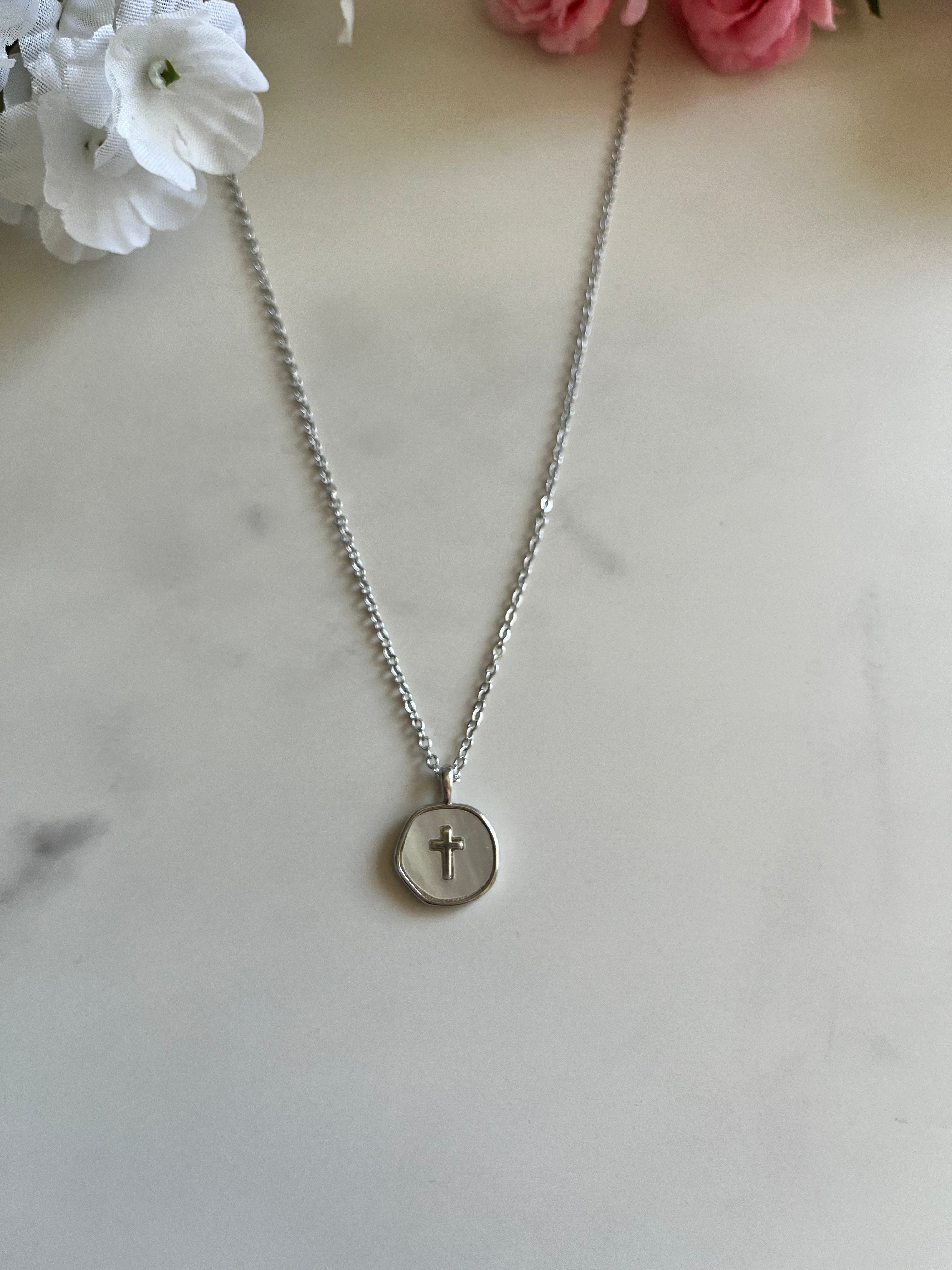 Silver cross pendant necklace with round disc charm centered on chain