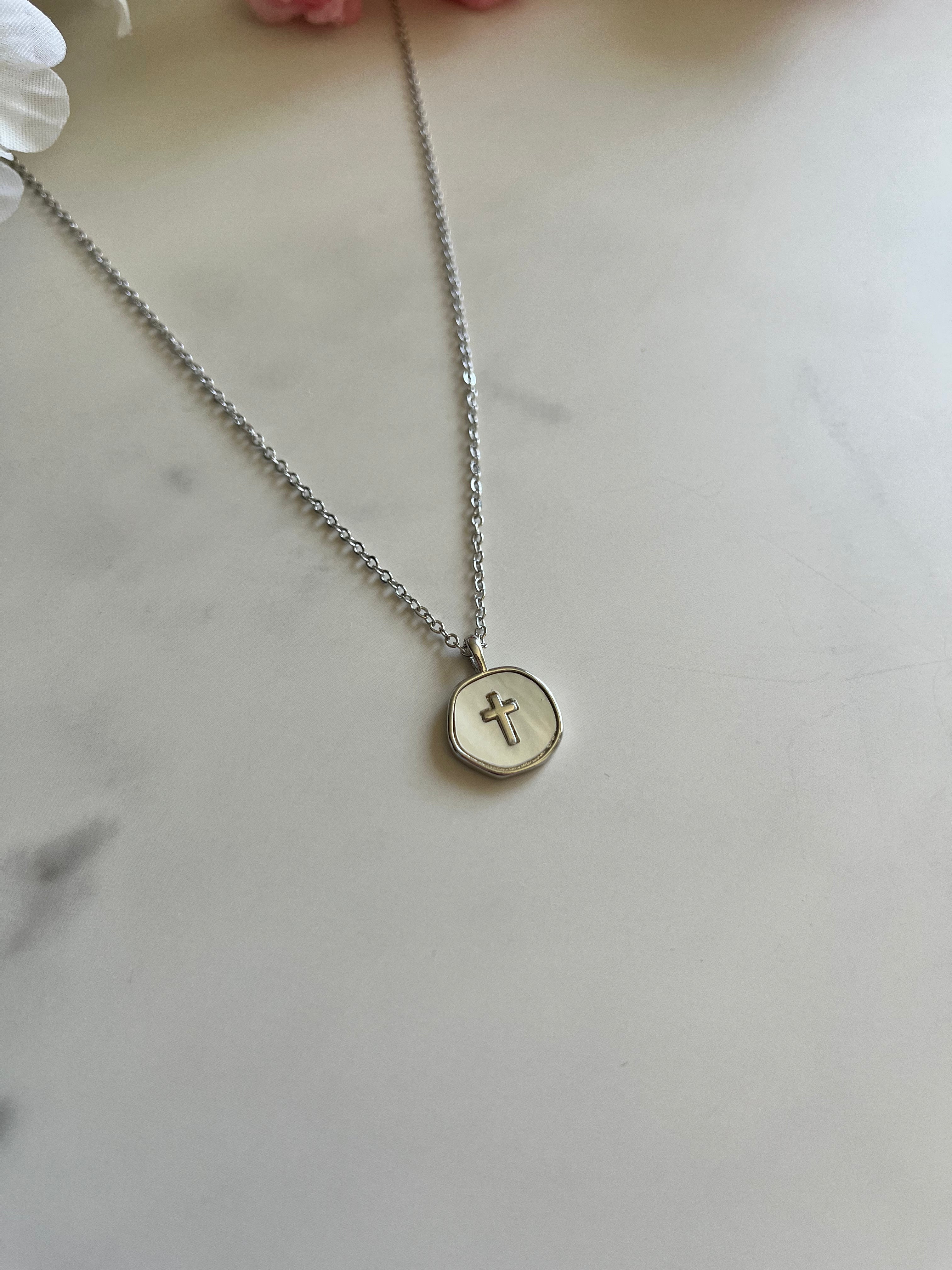 Silver cross pendant necklace with round disc charm, front view
