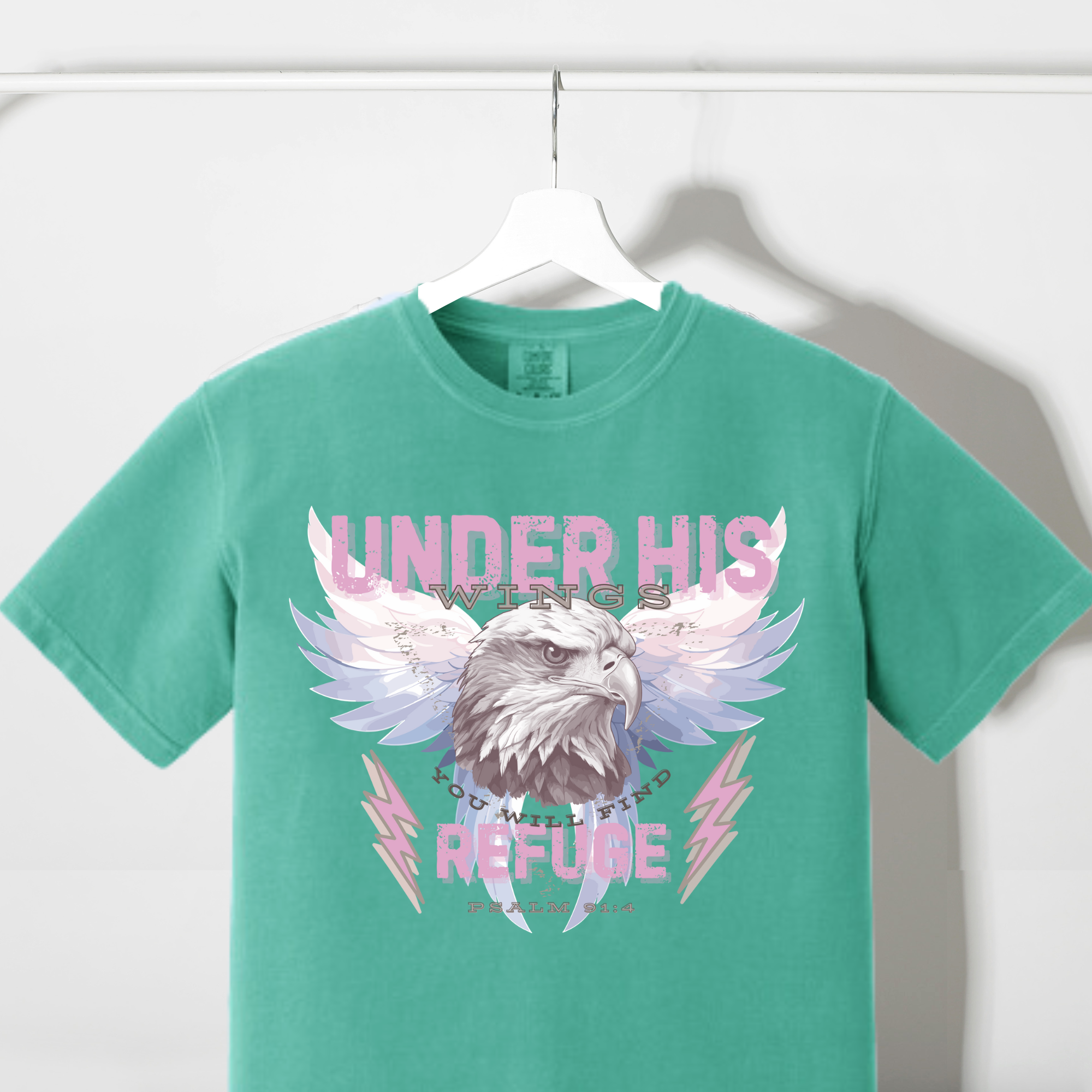Teal T-shirt with eagle head and angel wings graphic on front, crew neck