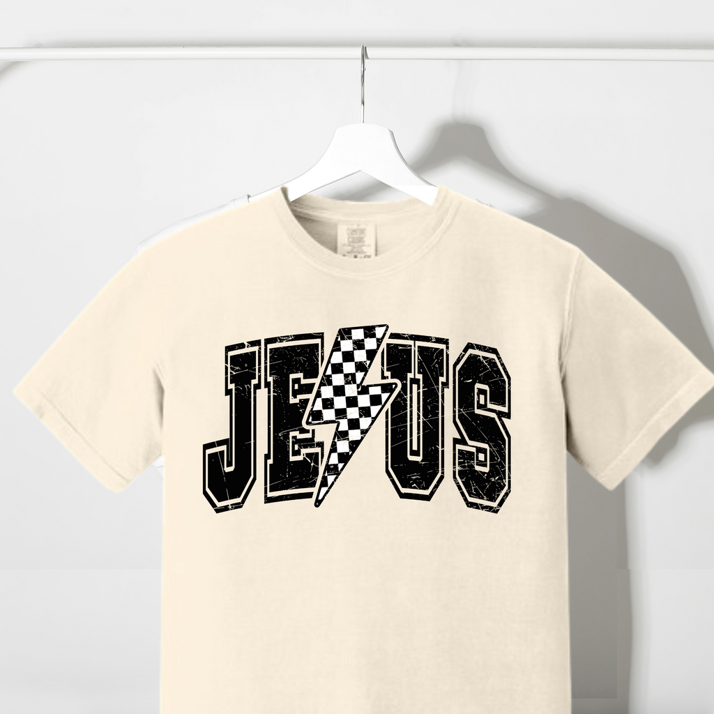 Cream graphic T-shirt with checkered lightning bolt and 'Jesus' text