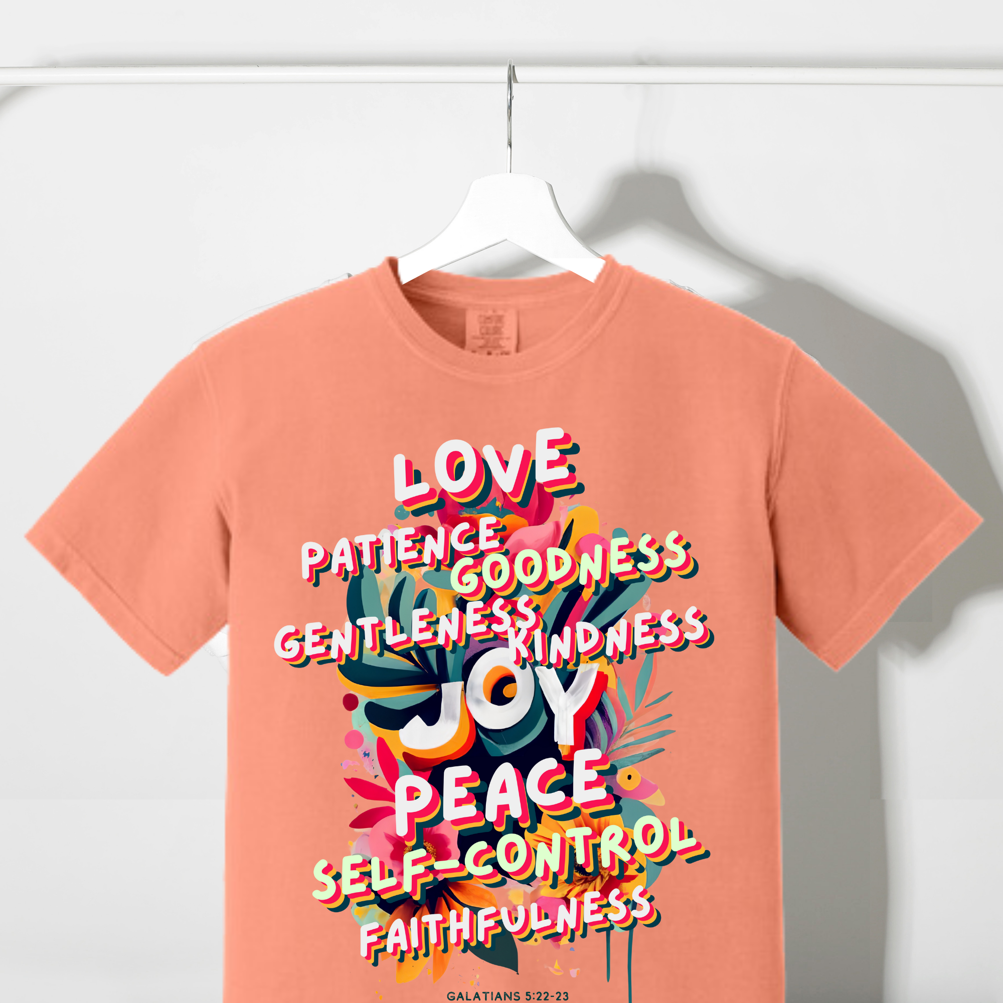 Coral T-shirt with colorful scripture-themed fruit and word graphic on front