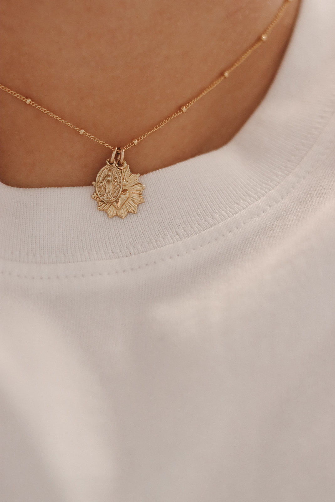 Gold-tone heart pendant necklace with small round charm on fine chain