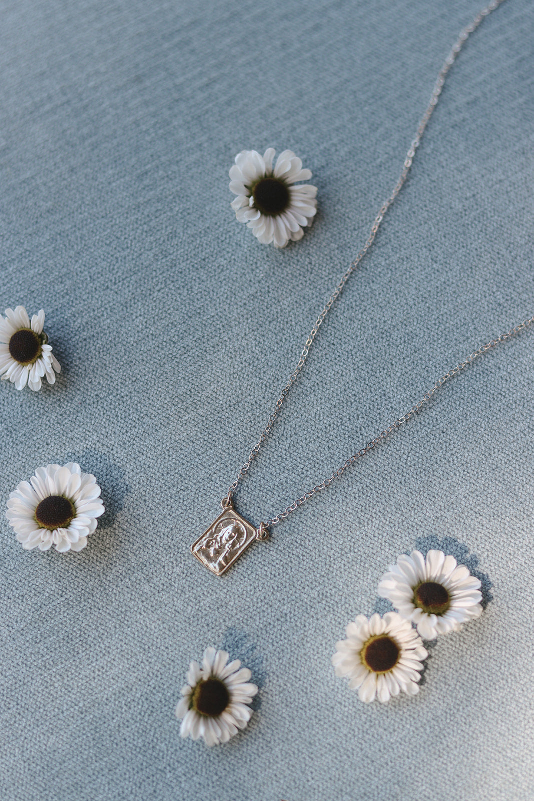 Silver scapular necklace with small rectangular saint medal pendant on silver chain