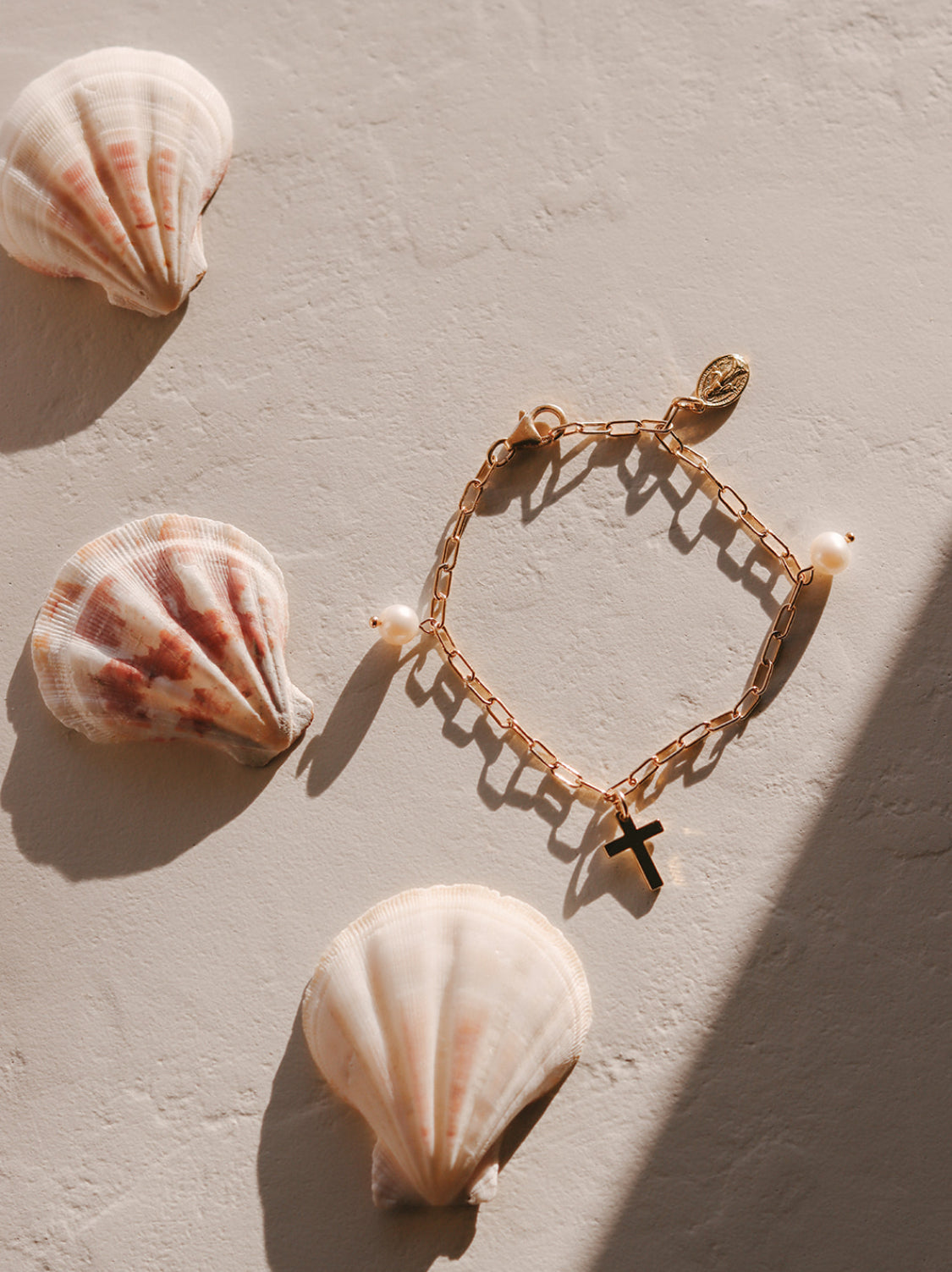 Gold link bracelet with white pearl beads and two cross charms