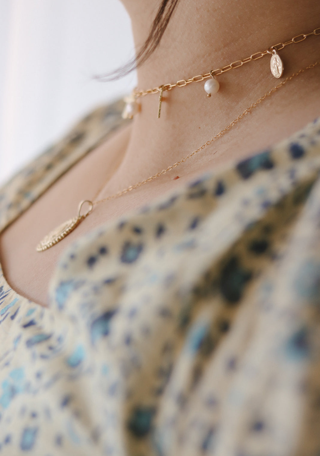 Gold-tone necklace close-up with cross charms and small pearl accents.