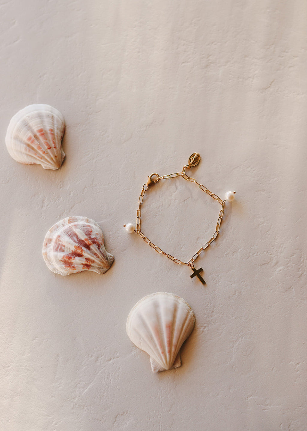 Set of two gold-tone beaded bracelets with cross charms and white pearl accents