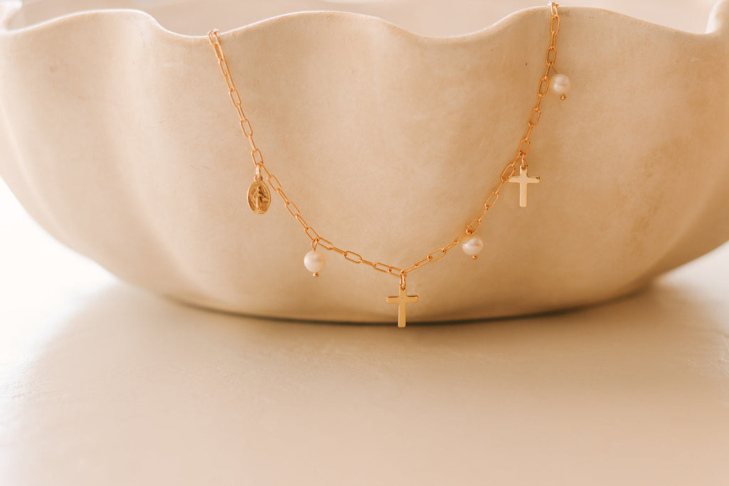 Gold cross charm necklace with pearl drops and round disc accent