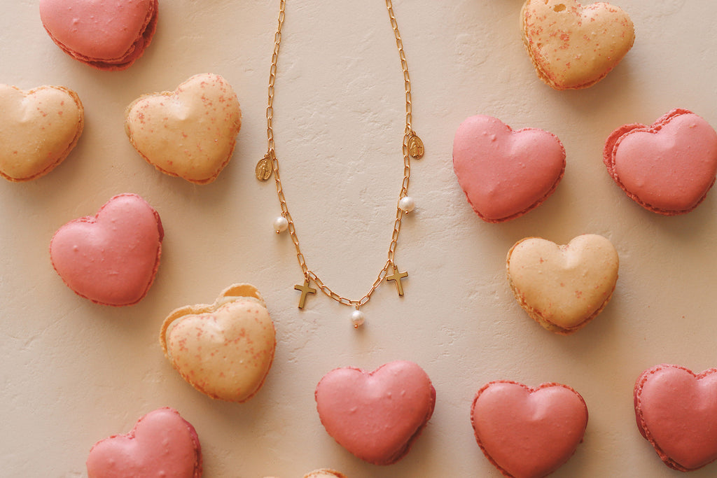 Gold-tone layered necklace with cross charms and pearl accents.