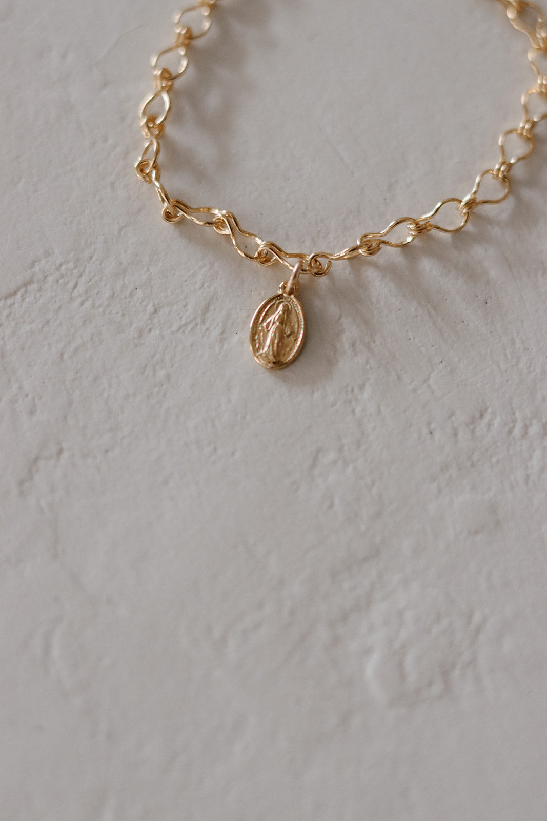 Gold-tone chain bracelet with oval medal charm detail