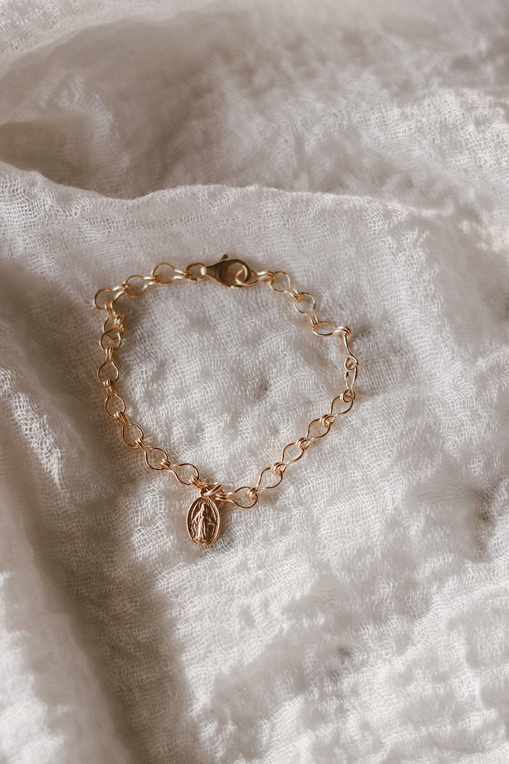 Gold-tone chain bracelet with oval medal charm and small link pattern