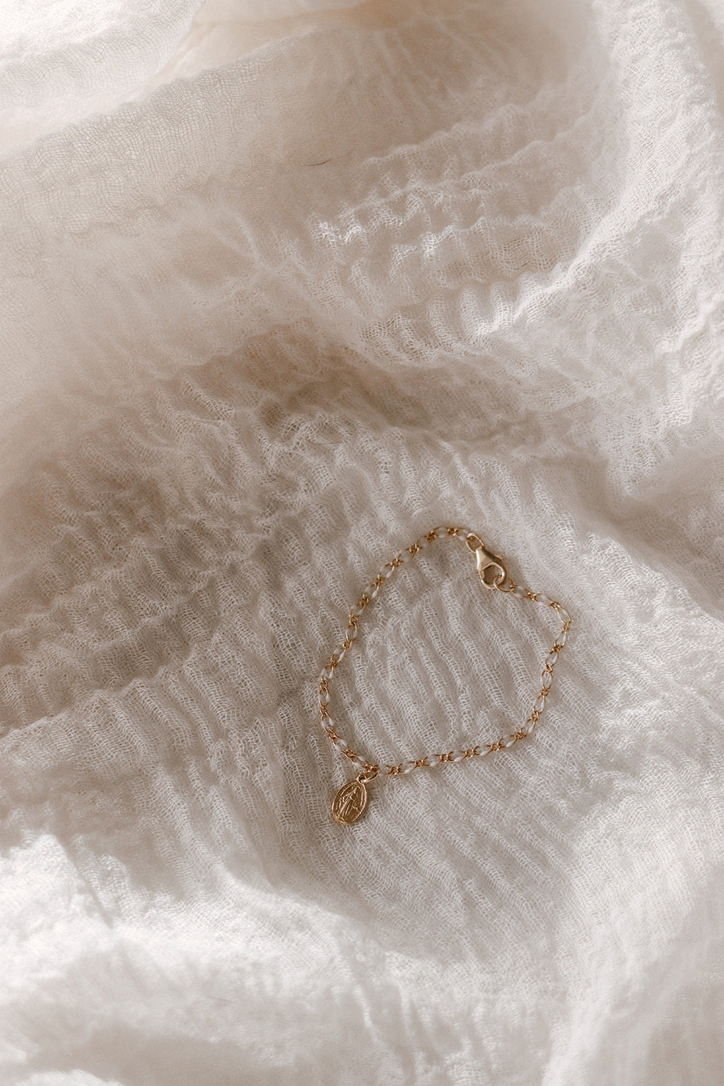 Gold chain bracelet with oval Miraculous Medal charm and open loop