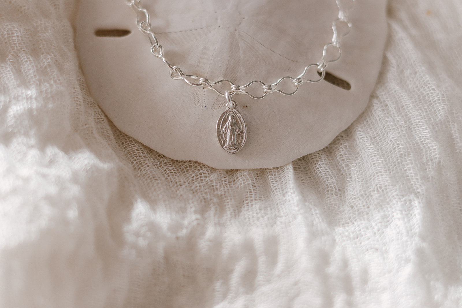 Sterling silver charm bracelet with oval Marian medallion, chain links, and clasp
