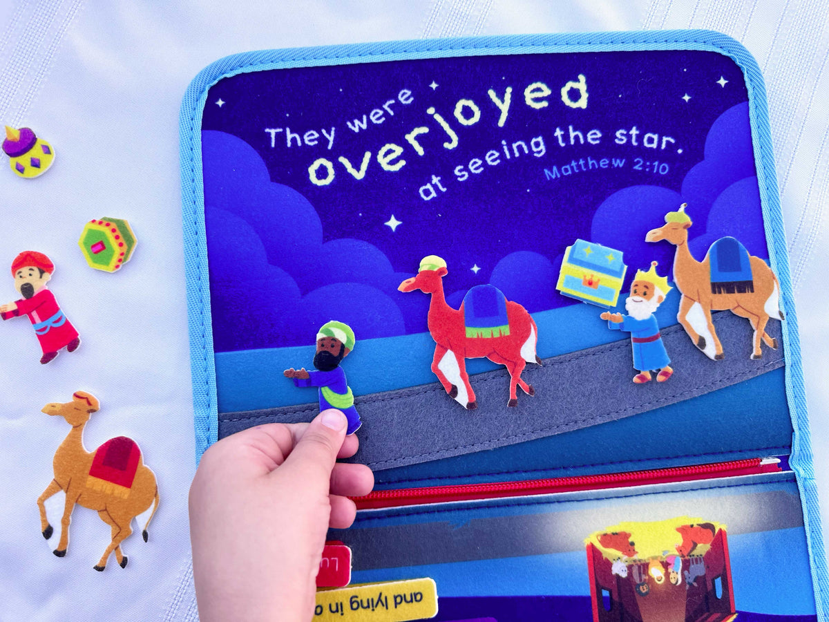 Nativity busy book open page with verse text and shepherd figures walking toward a star