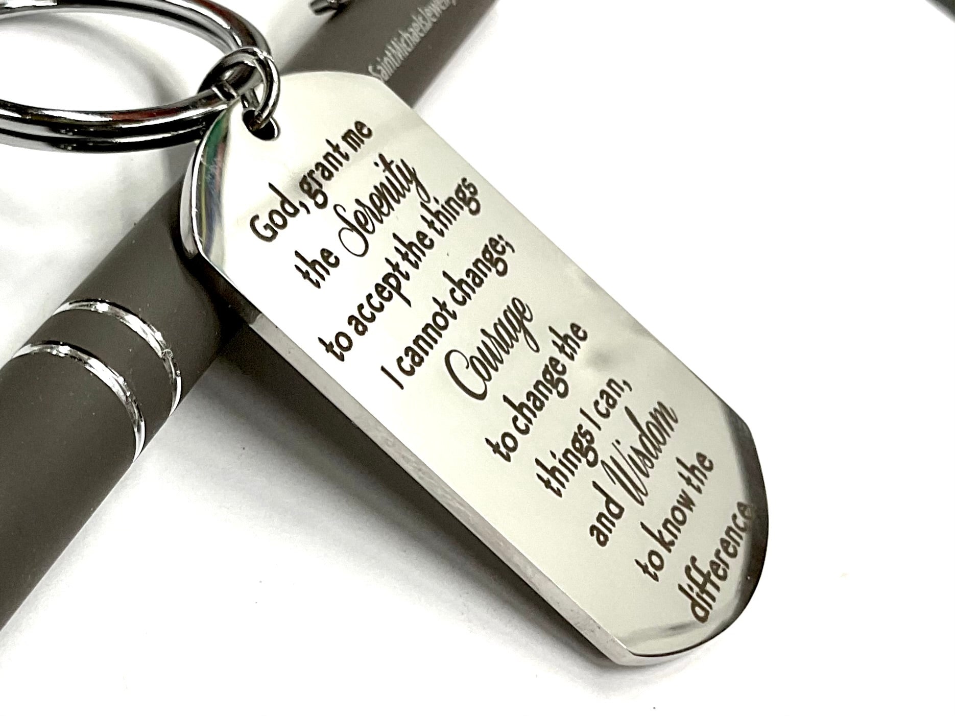 Silver dog tag keychain with Serenity Prayer lettering and split key ring, close-up