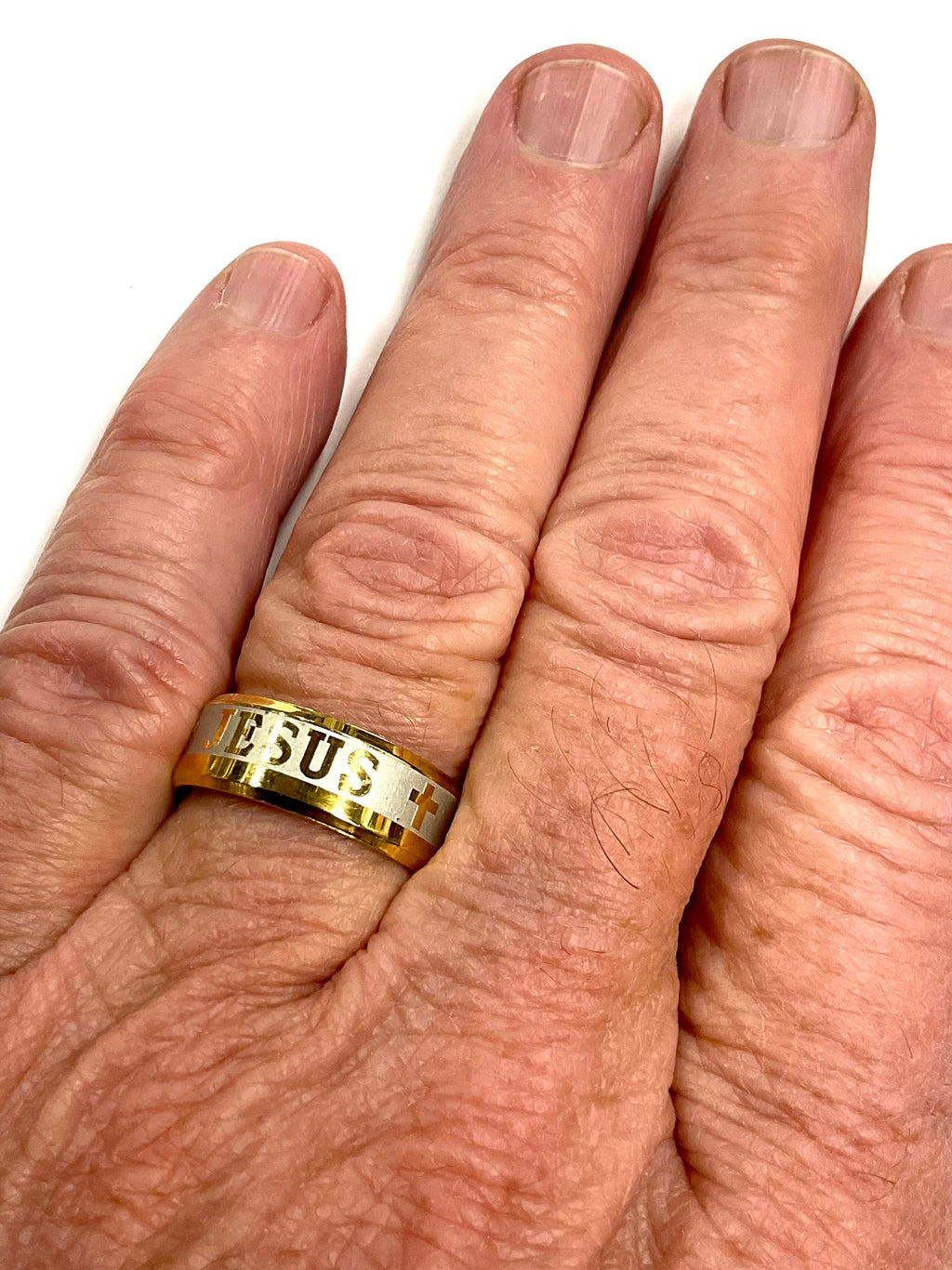 Gold wide ring with 'JE US' engraving, worn on hand
