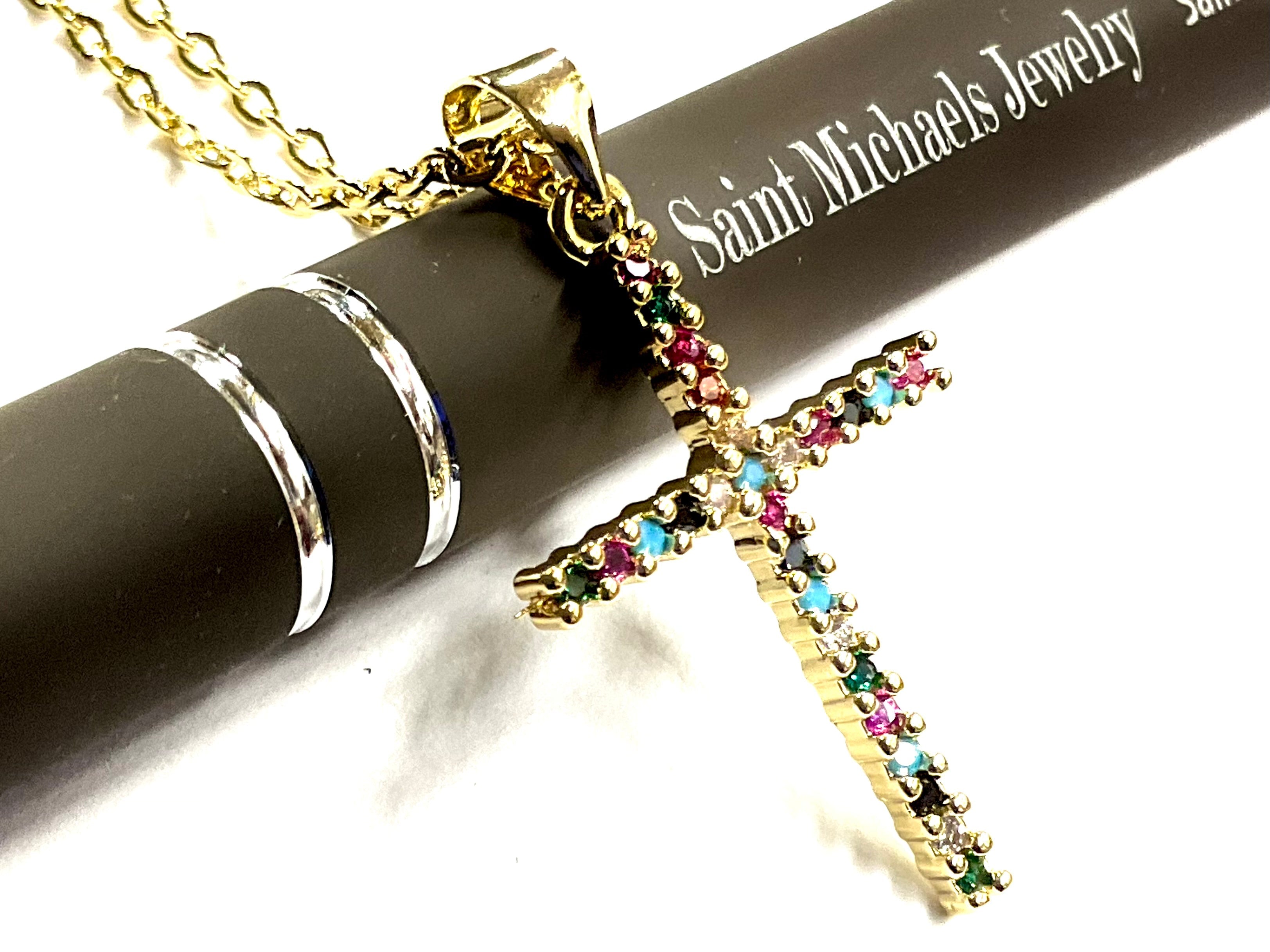 Gold cross necklace with multicolor CZ stones on a chain, close-up view