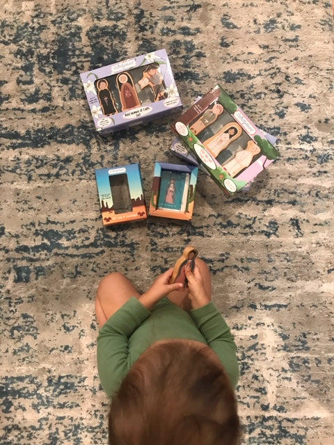 Religious wooden peg figure set pieces and boxes on carpet, overhead view