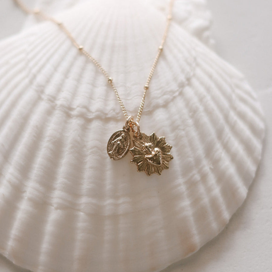 Gold-tone heart and medal pendant necklace with two charms centered on chain