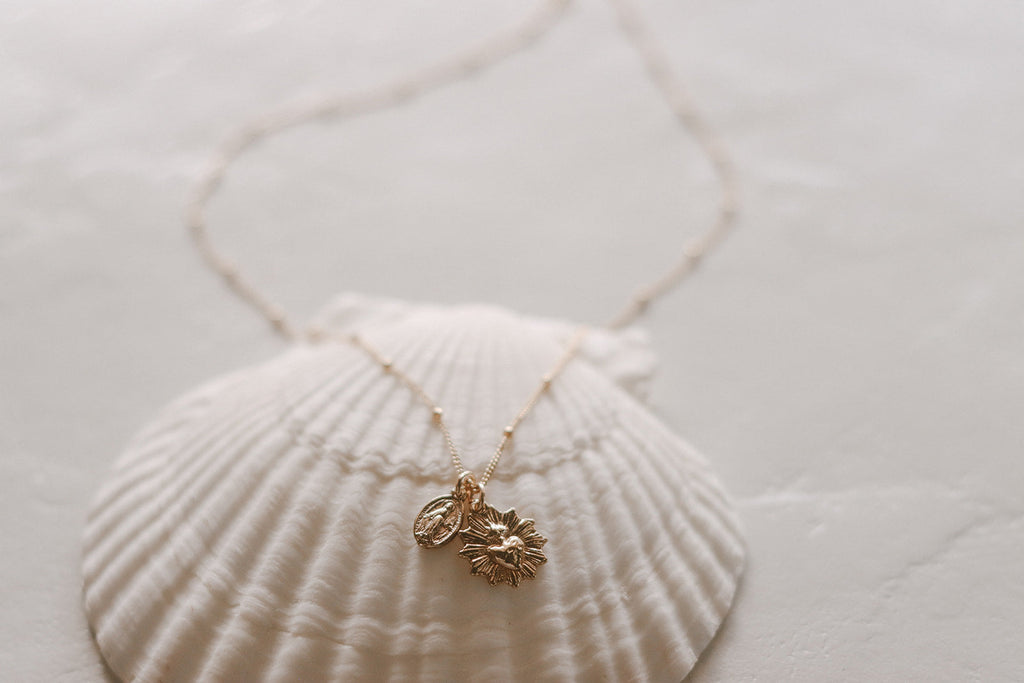 Gold-tone pendant necklace with sacred heart medal charm on fine chain