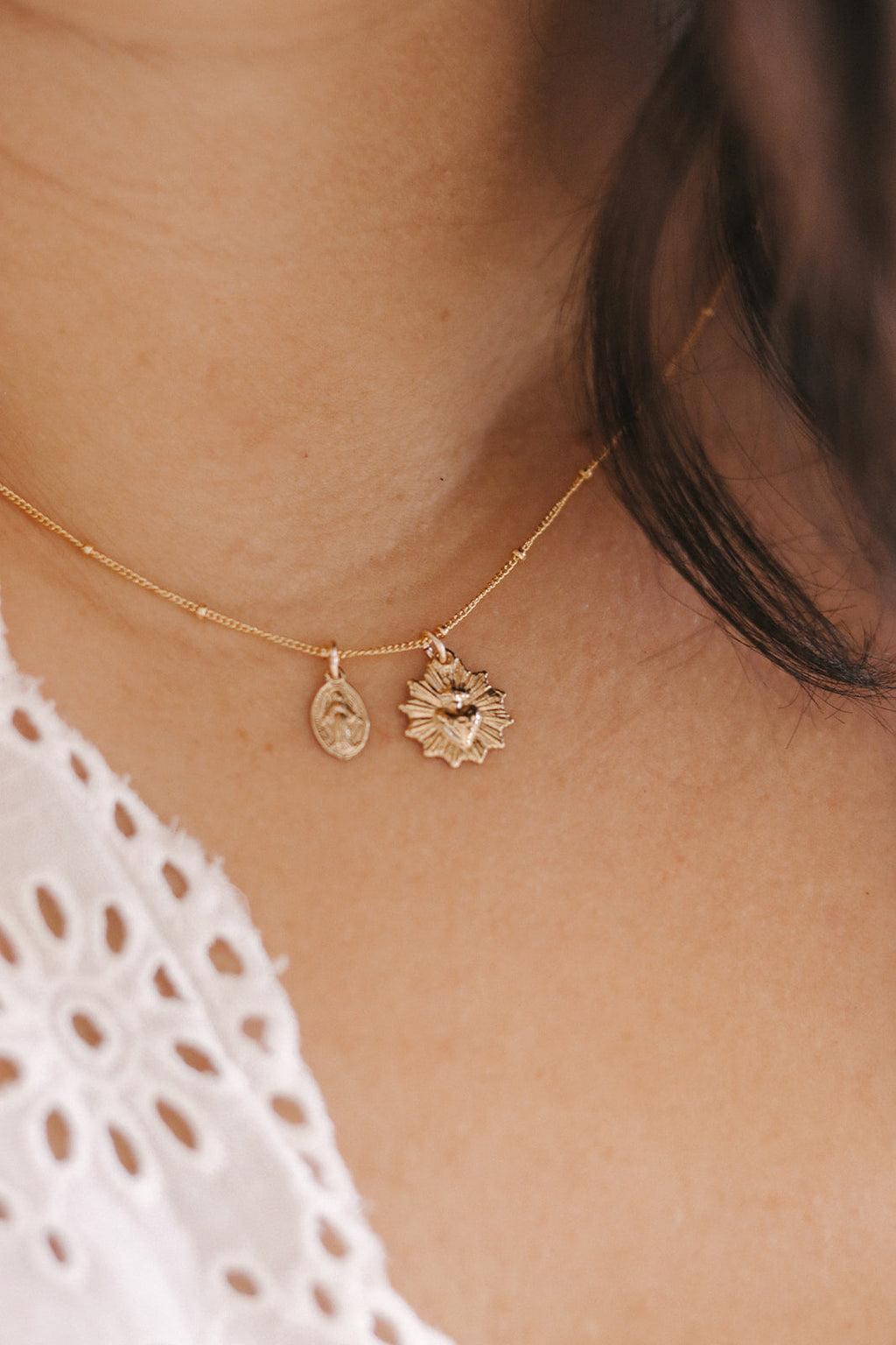Gold-tone heart and starburst charm necklace with two pendants on chain