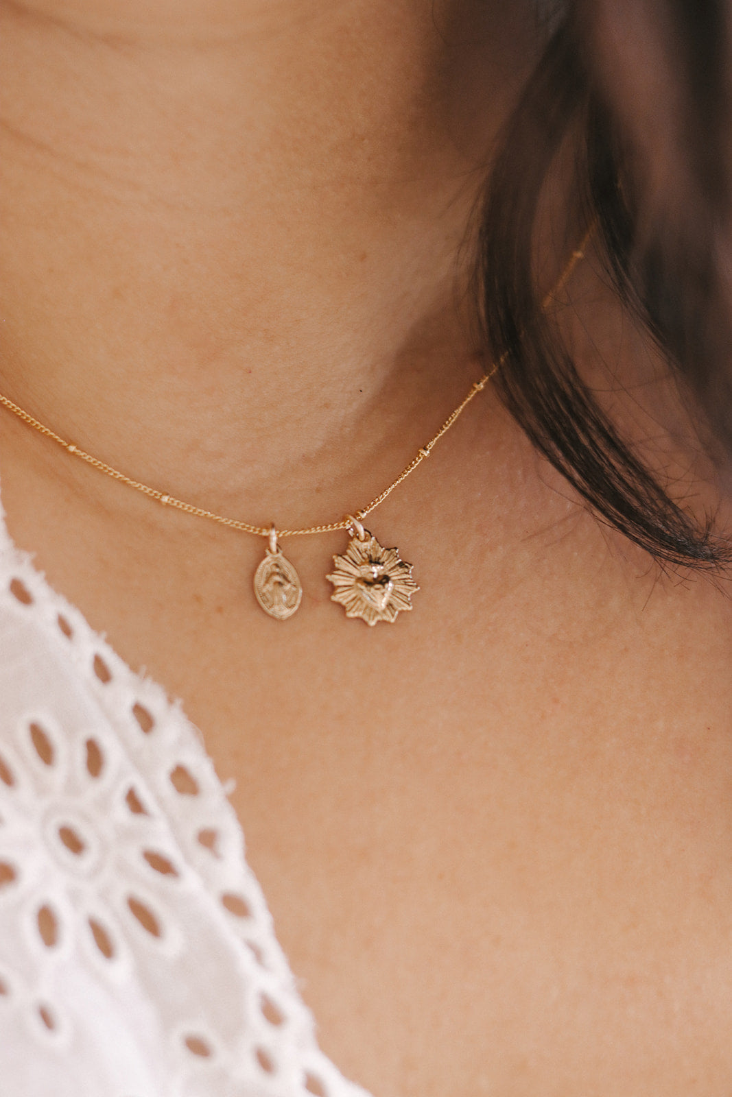 Gold-tone heart and starburst charm necklace with two pendants on chain