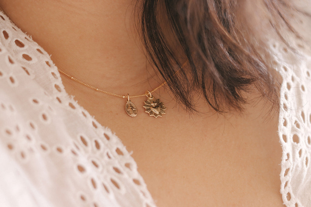 Gold-tone necklace with small heart and starburst pendants on thin chain