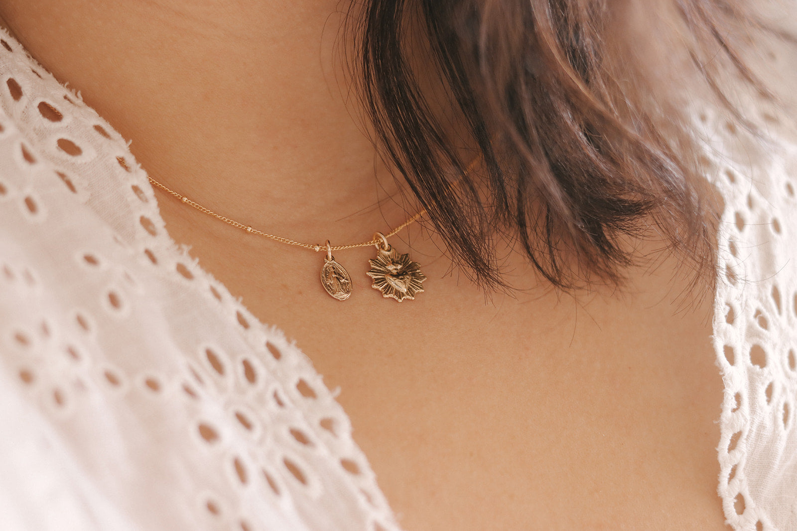 Gold-tone necklace with small heart and starburst pendants on thin chain