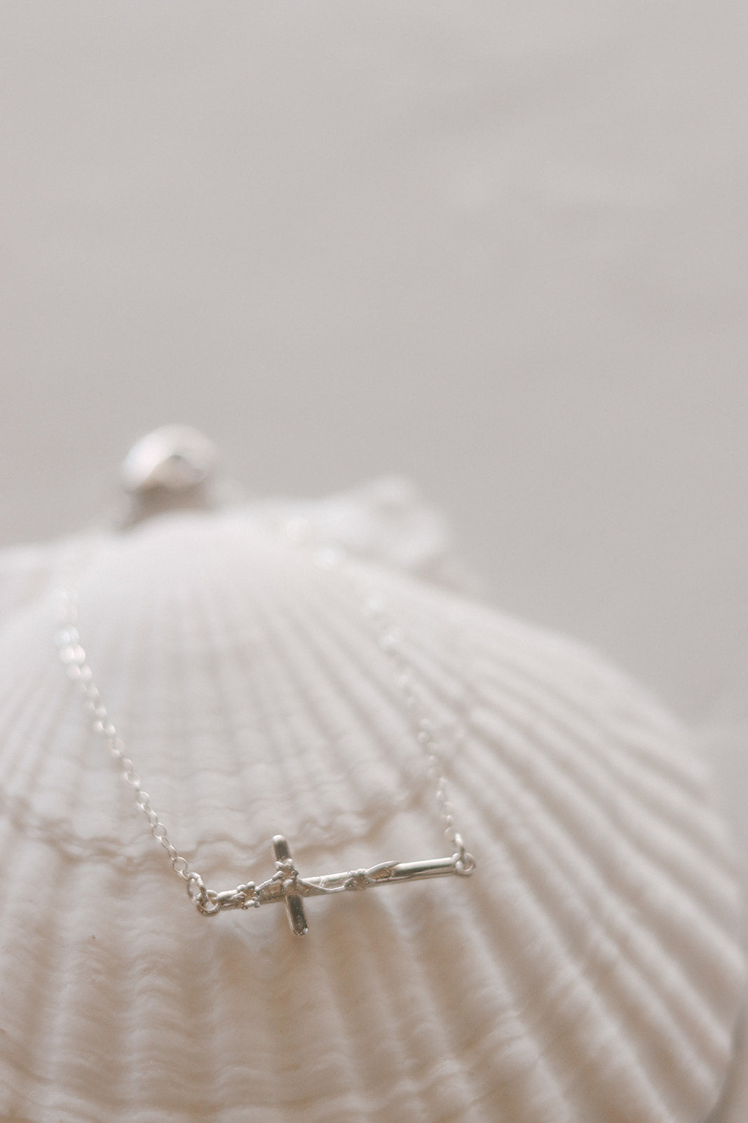 Silver cross bracelet close-up with fine chain and small cross charm
