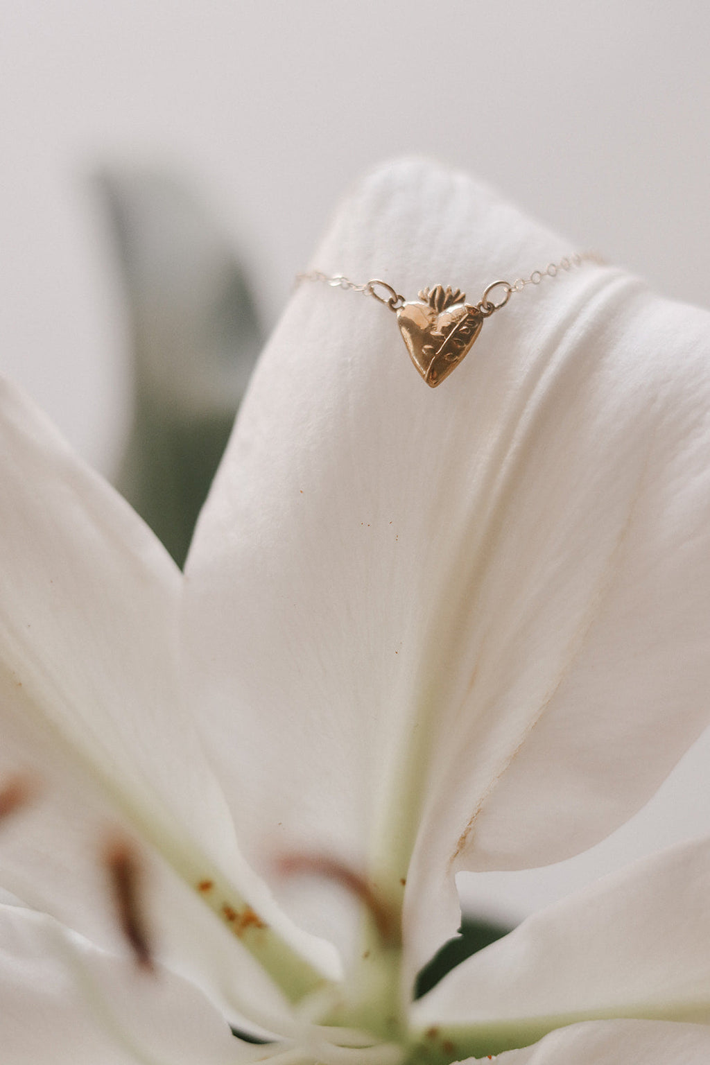 Gold-tone heart charm necklace with small crown-like detail